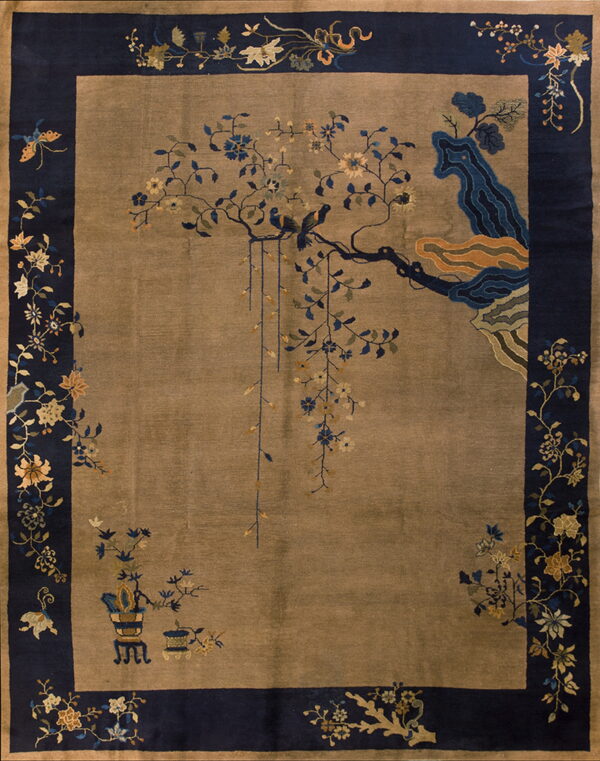 Taupe rug with a wide navy blue border and intricate pattern featuring birds on a flowering branch.