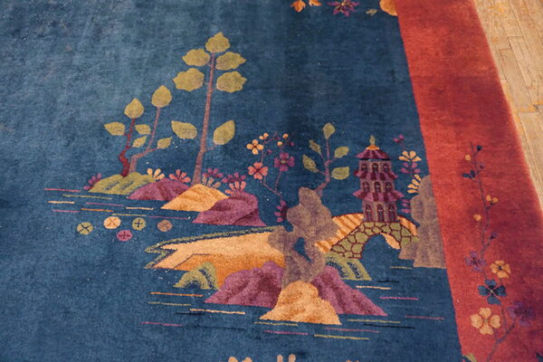 High-pile blue rug featuring a detailed landscape pattern with a purple pagoda and a wide red border.