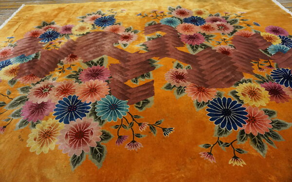 High-pile saffron rug displaying large blue, pink, and yellow floral bouquets alongside brown geometric patterns.