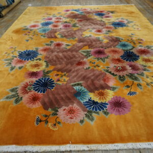 Ochre rug features an ornate central brown branch motif surrounded by bright multicolored blossoms.