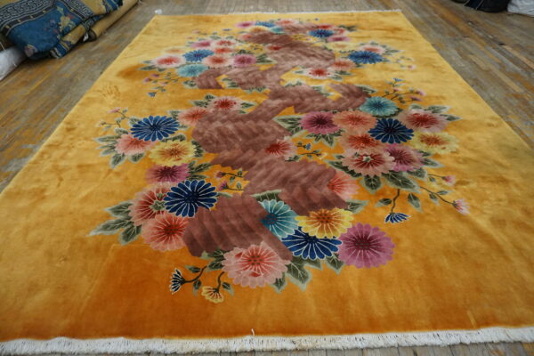Ochre rug features an ornate central brown branch motif surrounded by bright multicolored blossoms.