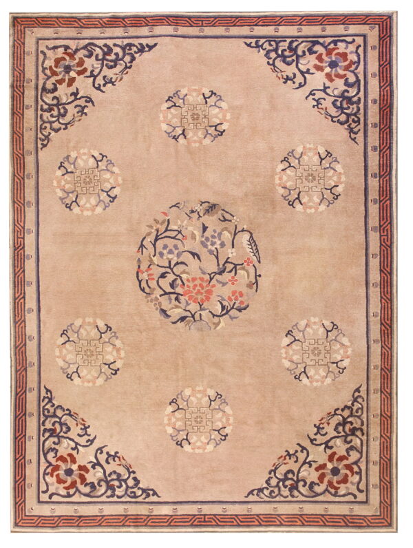 Plush tan rug featuring a central floral pattern in blue, coral, and maroon with geometric borders.