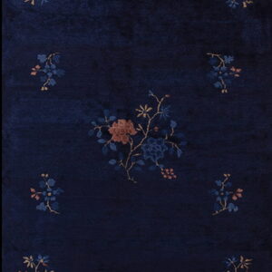 A dark navy blue rug runner with a visible nap, featuring scattered floral motifs in rust and gold.