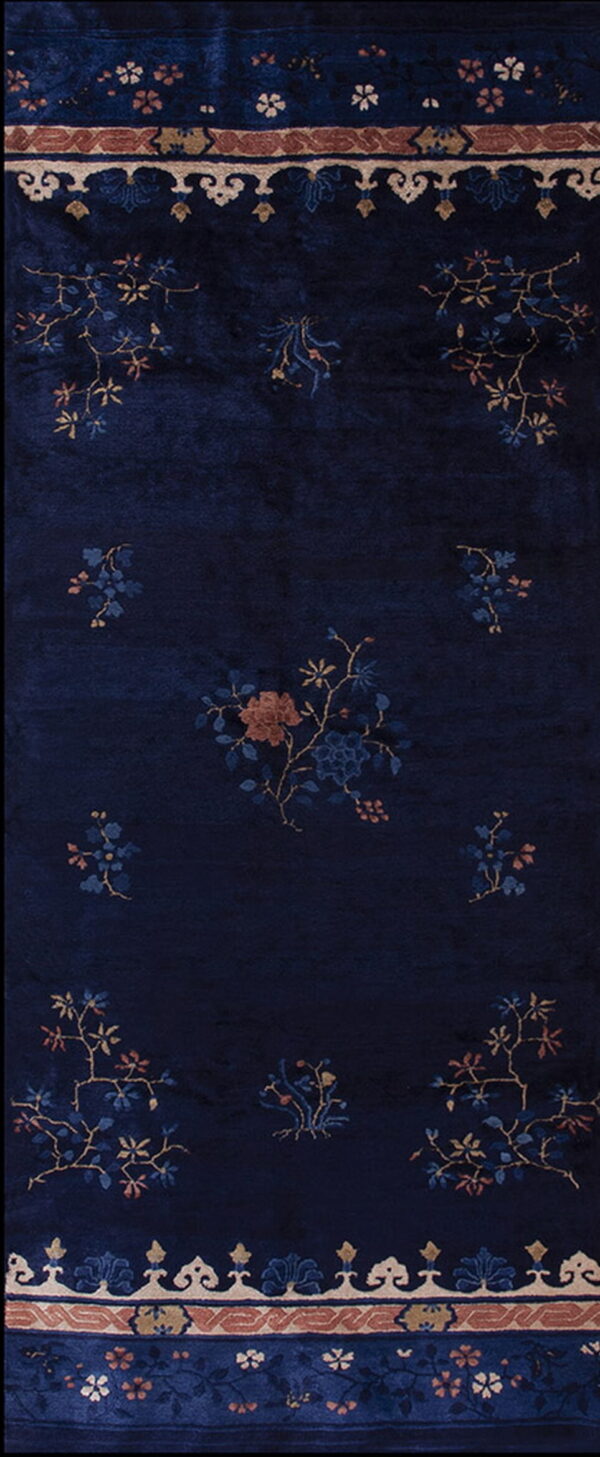 A dark navy blue rug runner with a visible nap, featuring scattered floral motifs in rust and gold.