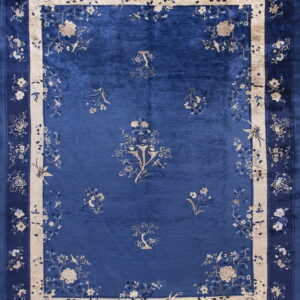 Lustrous cobalt blue rug with scattered floral motifs and an ornate beige and blue border.