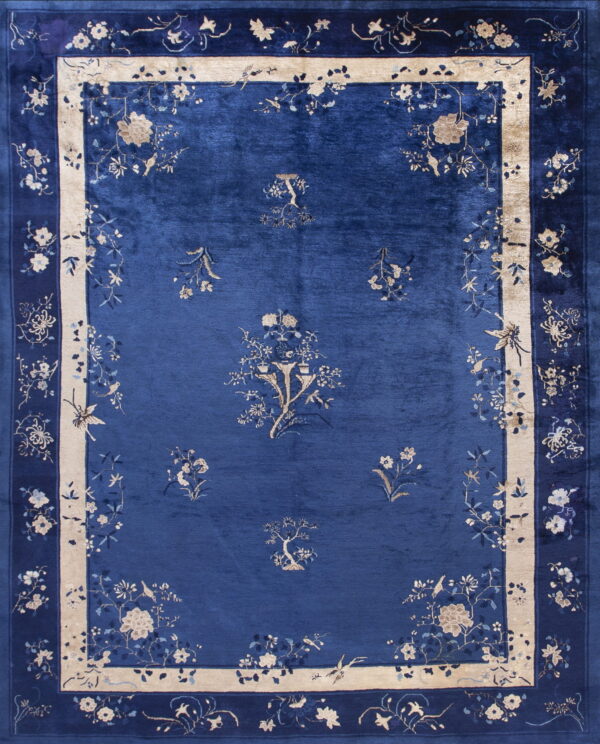 Lustrous cobalt blue rug with scattered floral motifs and an ornate beige and blue border.