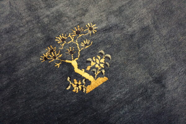 Textured dark blue rug features a detailed golden yellow tree pattern with small light blue and gray accents.