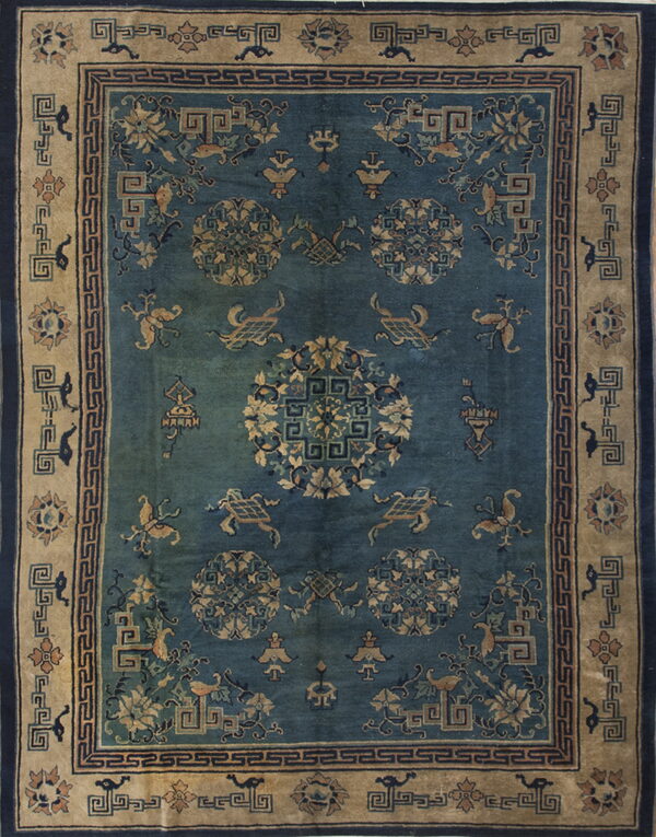 Dark teal rug with tan borders and a detailed pattern of medallions, stylized creatures, and geometric motifs.
