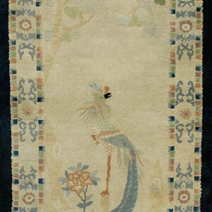 Beige runner rug with a bird and tree pattern, framed by a border of muted blue, green, and rust tones.
