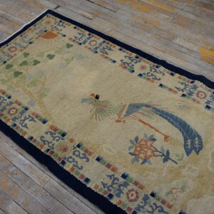 Tan rug runner featuring a blue and green bird design and a dark navy border on worn wood planks.