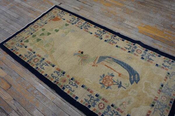 Tan rug runner featuring a blue and green bird design and a dark navy border on worn wood planks.