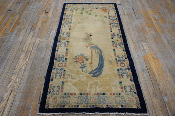 Beige runner rug with a colorful bird and tree pattern displayed on distressed wooden planks.