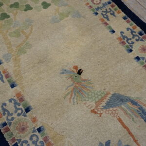 Beige pictorial rug featuring a stylized blue and green bird and soft green tree motifs on wood planks.
