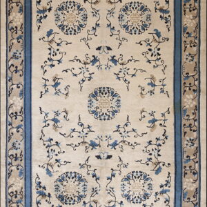 Beige rug with blue floral patterns and medallions, framed by a thick solid blue border.