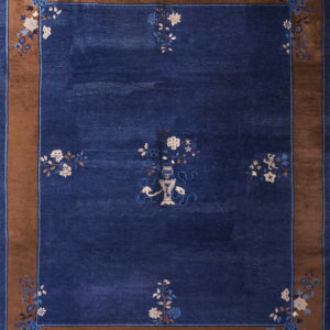 Low-pile blue rug features a central vase and scattered floral sprays within a wide brown border.