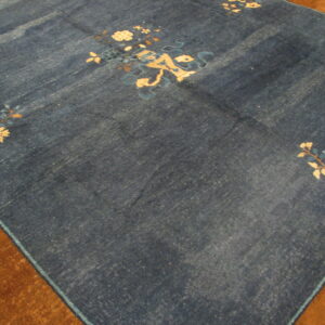 Deep blue rug with scattered cream and light blue floral patterns on a plush brown border.