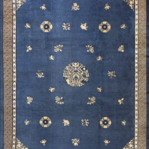 Deep blue rug with scattered tan medallions and floral motifs surrounded by an intricate geometric border.