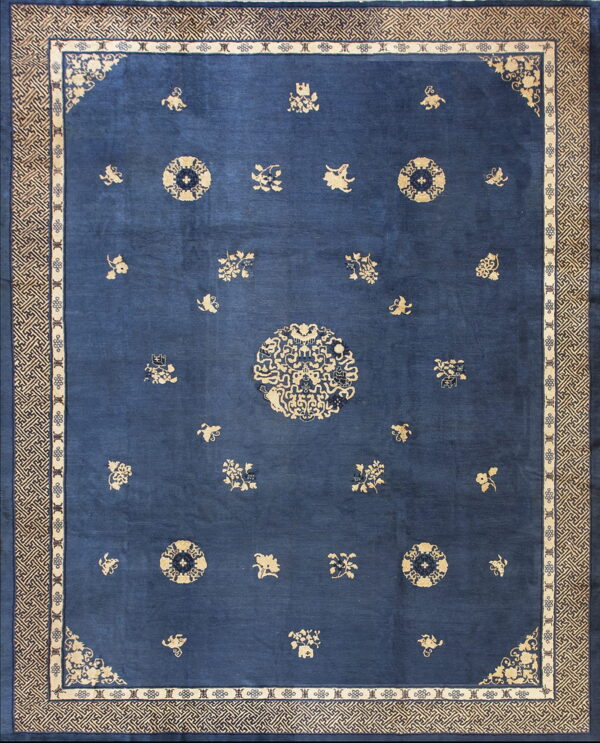 Deep blue rug with scattered tan medallions and floral motifs surrounded by an intricate geometric border.