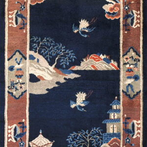 A navy blue rug with a traditional Asian scenic pattern, featuring pagodas, birds, and trees, framed by a rust border.
