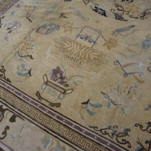 Low-pile tan rug featuring complex patterns in brown, light blue, and purple with a prominent geometric border.