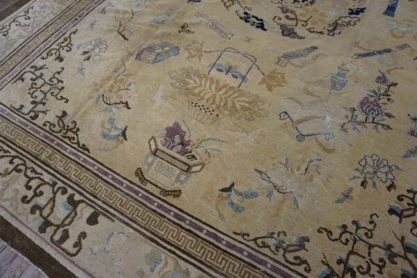 Low-pile tan rug featuring complex patterns in brown, light blue, and purple with a prominent geometric border.
