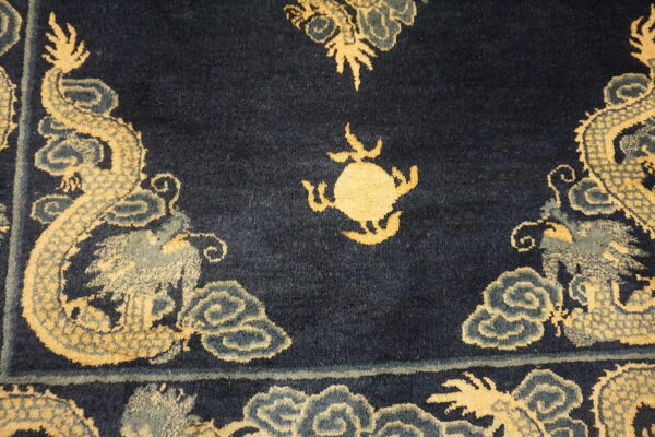 Navy cut-pile rug featuring large golden dragons, swirling blue-gray clouds, and a central round motif.