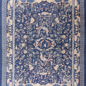 Navy blue rug with a dense traditional pattern in beige and pink, framed by geometric key borders.