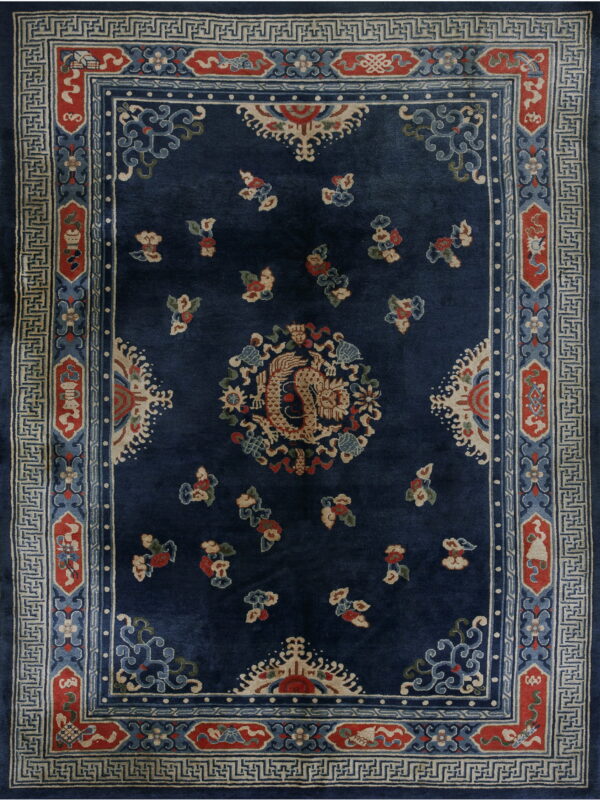 Dark blue rug with a beige dragon center, red details, and a geometric cream and blue fretwork border.