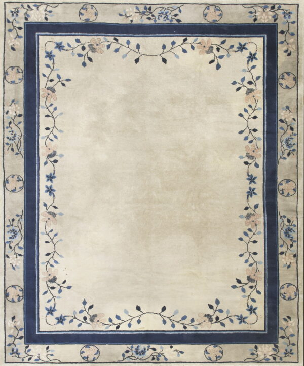 Ivory rug with a wide floral border featuring pink and blue flowers and vines around a solid center.