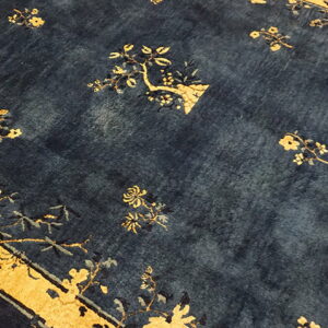 Deep navy rug with scattered yellow floral motifs and a visible gold border section.