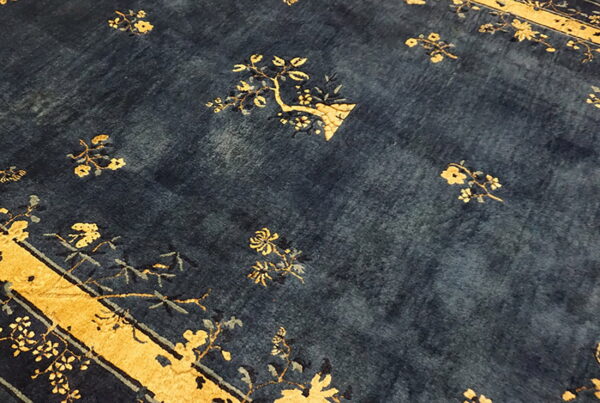 Deep navy rug with scattered yellow floral motifs and a visible gold border section.