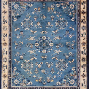 Blue field rug with detailed ivory and dark blue floral and medallion motifs inside a wide tan border.