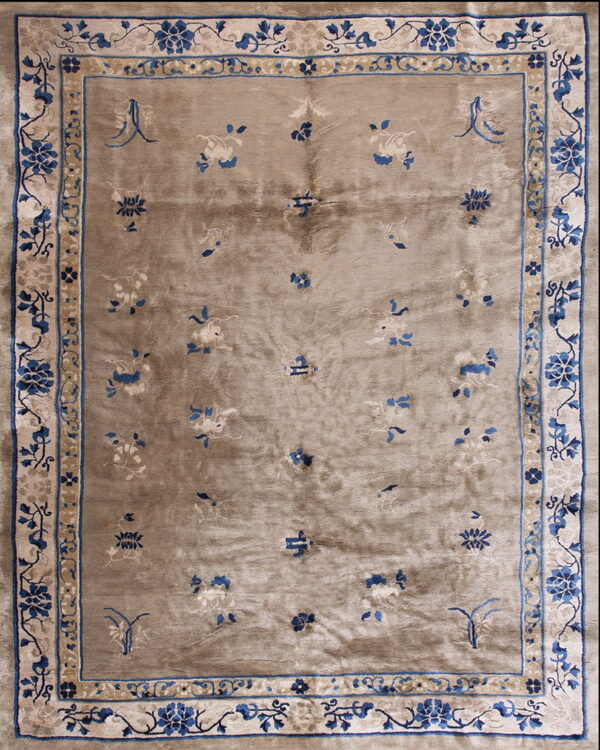 Low-pile rug with a shimmering taupe field, scattered florals, and wide blue and cream botanical borders.