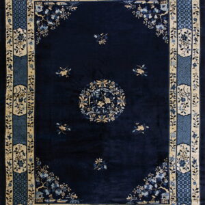 Plush navy rug with a central medallion and complex tan and blue floral borders.