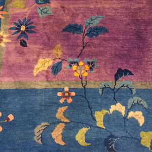 A plush rug detail shows multicolored floral vines across distinct purple and deep blue color fields.