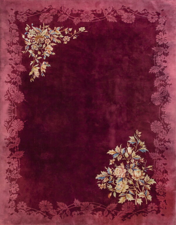 Burgundy high-pile rug with a tonal pink floral border and multicolor flower bouquets in opposite corners.
