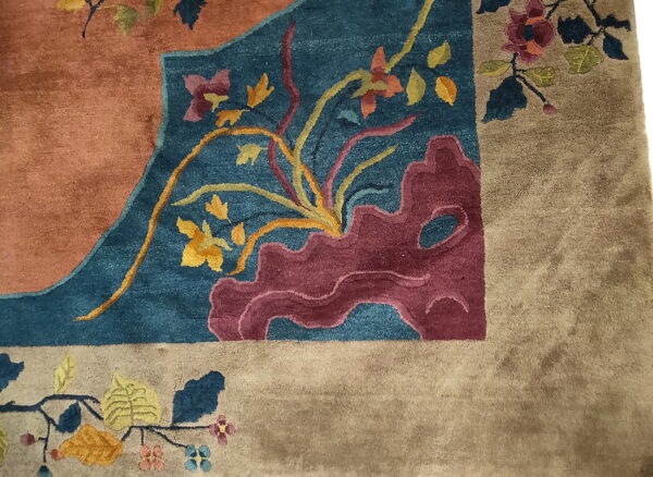 Plush rug detail featuring an ornate pattern in rust, teal blue, yellow, and tan colors.