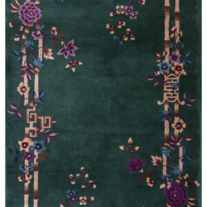 Deep green rug with a bamboo border framing multicolored flowers and stylized key patterns.