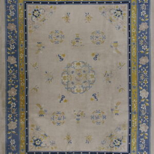 Beige rug with a wide blue floral border and contrasting yellow guard stripes around scattered traditional designs.