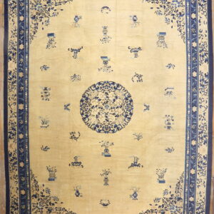 Pale yellow rug with scattered blue motifs, a central medallion, and an ornate dark blue border.
