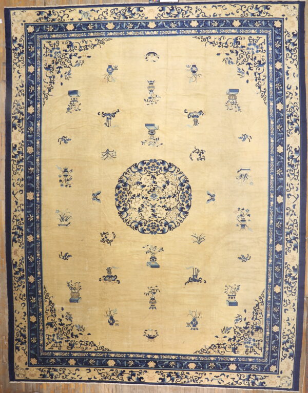 Pale yellow rug with scattered blue motifs, a central medallion, and an ornate dark blue border.