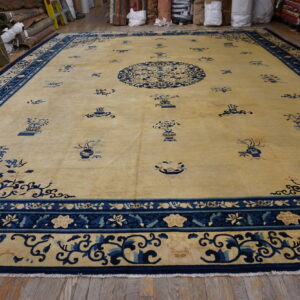 Oversized beige rug with a circular navy blue medallion and decorative motifs on wood flooring.