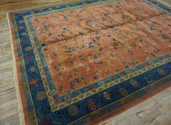 Terracotta and teal rug featuring an all-over floral pattern and symbolic borders on rustic wood floors.