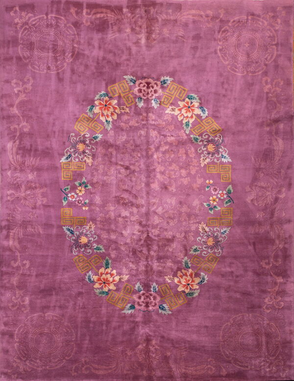 A high-pile magenta rug featuring a central oval medallion with colorful peach, green, and yellow floral designs.