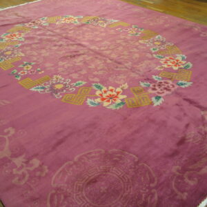 Plush magenta rug with subtle field patterns and a bright circular border on brown wood floor.