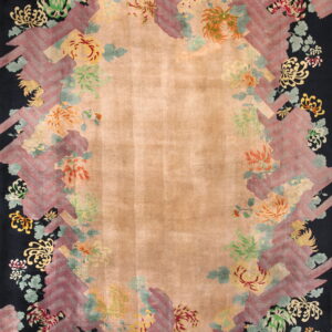 Tan central field rug featuring a black border covered in vibrant flowers and a decorative maroon zigzag frame.