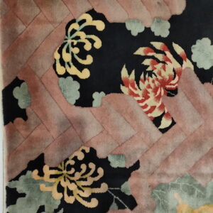 High-pile rug featuring carved yellow and red flowers on black, surrounded by a pink diagonal border.