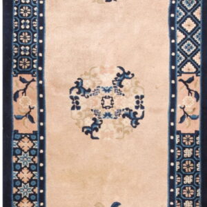 Runner rug with a pale pink field and dark blue border, patterned with repeating traditional medallions and vase motifs.