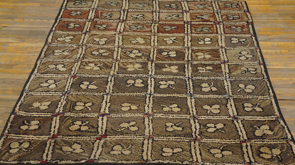 Brown and taupe textured rug with a checkered design and stylized clover motifs on wood floor.