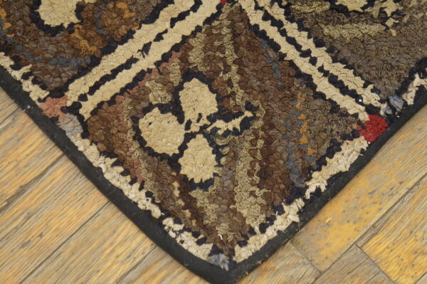 Textured rug corner features abstract brown, tan, and black patterns over light wood flooring.